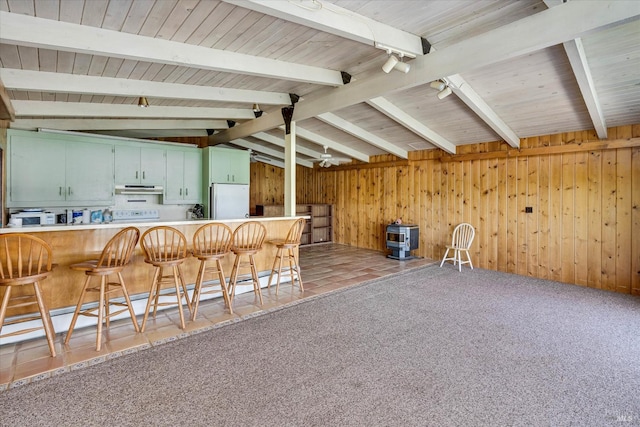 kitchen featuring a peninsula, carpet, freestanding refrigerator, and under cabinet range hood