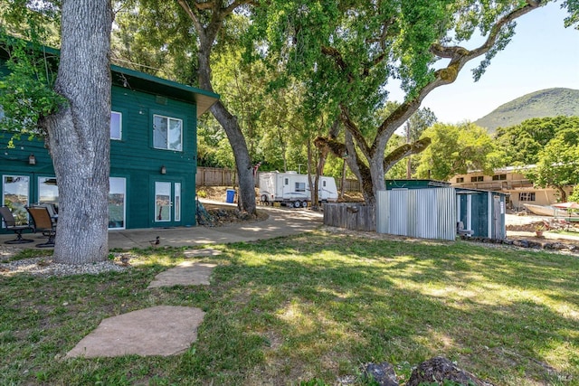 view of yard featuring fence and a mountain view