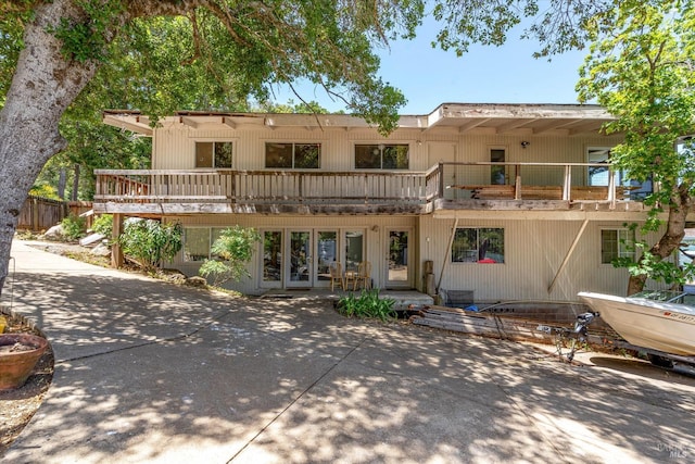 rear view of house featuring a patio area and a balcony