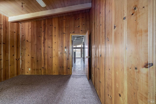 hall with wood ceiling, carpet flooring, beamed ceiling, and wooden walls