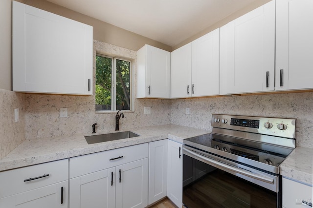 402 Grove Ave, Ukiah, CA 95482 - kitchen featuring stainless steel electric range oven, white cabinets, a sink, light stone countertops, and decorative backsplash