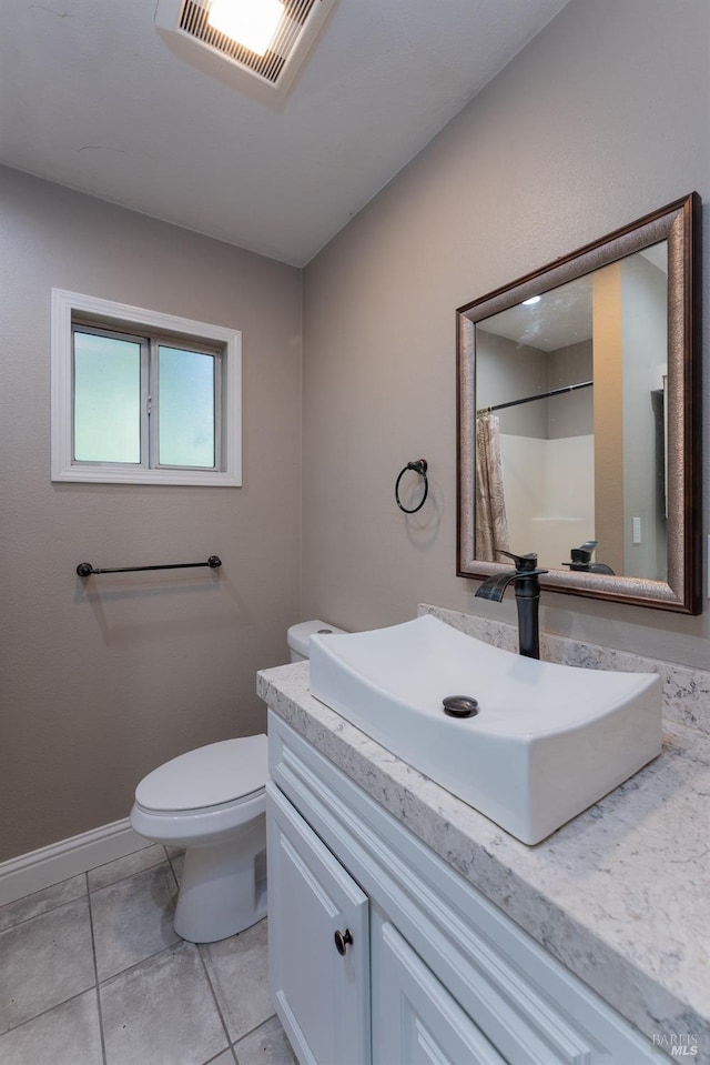 bathroom with tile patterned floors, curtained shower, vanity, and toilet