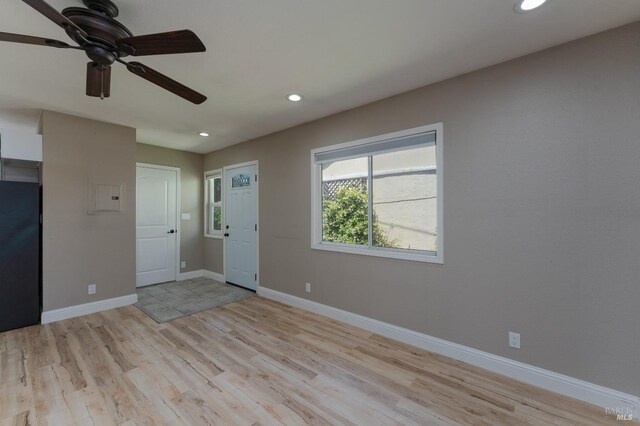 empty room with ceiling fan, light hardwood / wood-style flooring, and a wall unit AC