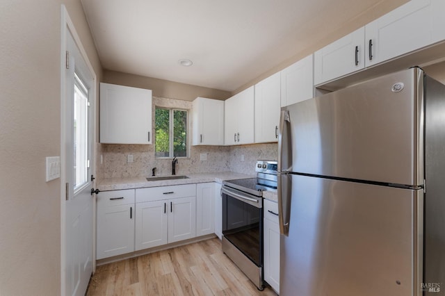 402 Grove Ave, Ukiah, CA 95482 - kitchen featuring tasteful backsplash, light wood-type flooring, white cabinets, stainless steel appliances, and a sink