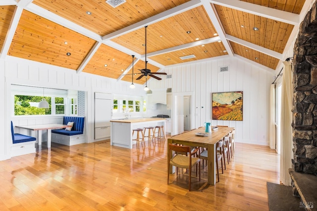 dining space featuring ceiling fan, light hardwood / wood-style floors, beam ceiling, high vaulted ceiling, and wooden ceiling