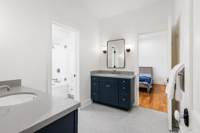 bathroom with a bath, hardwood / wood-style floors, and vanity