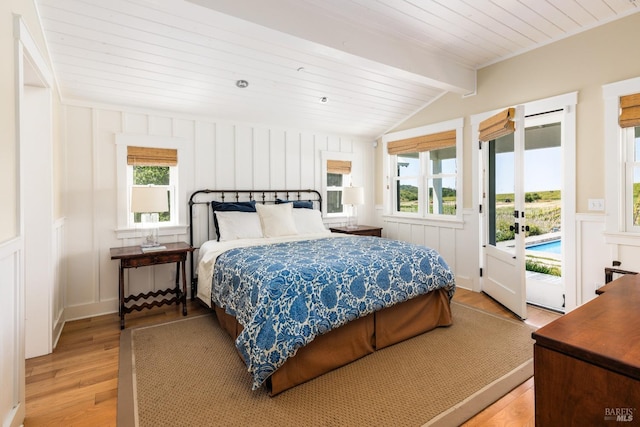 bedroom featuring access to outside, lofted ceiling with beams, and light hardwood / wood-style flooring