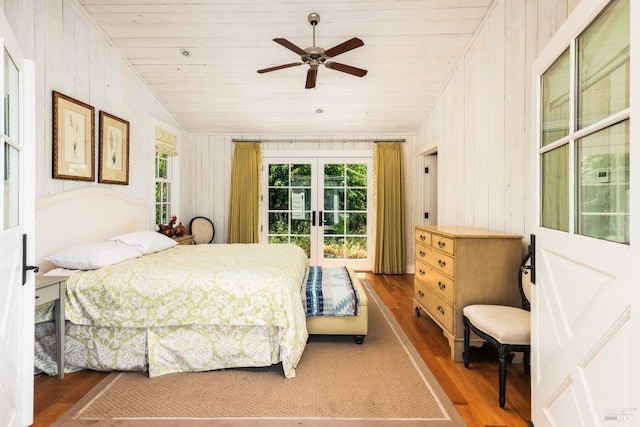 bedroom with wood walls, ceiling fan, hardwood / wood-style flooring, and wood ceiling