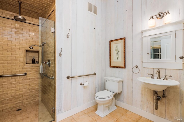 bathroom with walk in shower, sink, tile flooring, and toilet