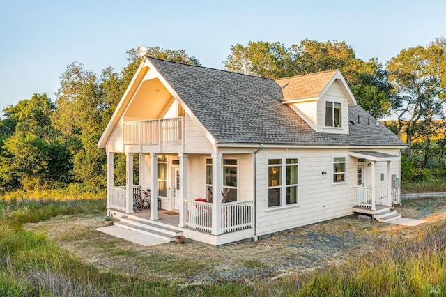 back of house featuring a balcony and covered porch