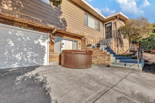 view of front of property featuring a garage and a hot tub