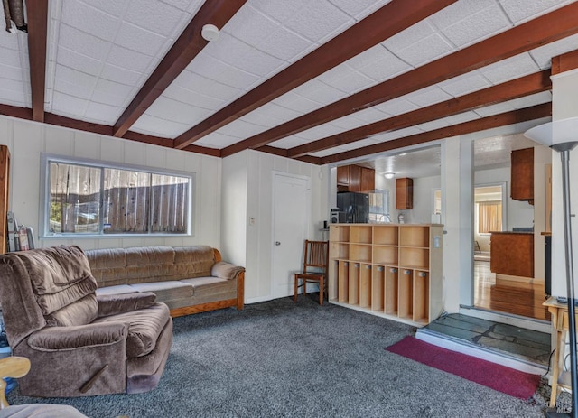 living room featuring beamed ceiling and carpet flooring