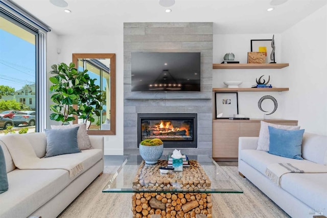 living room with tile walls, a healthy amount of sunlight, and a large fireplace