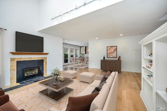 living room featuring recessed lighting, a fireplace, and wood finished floors