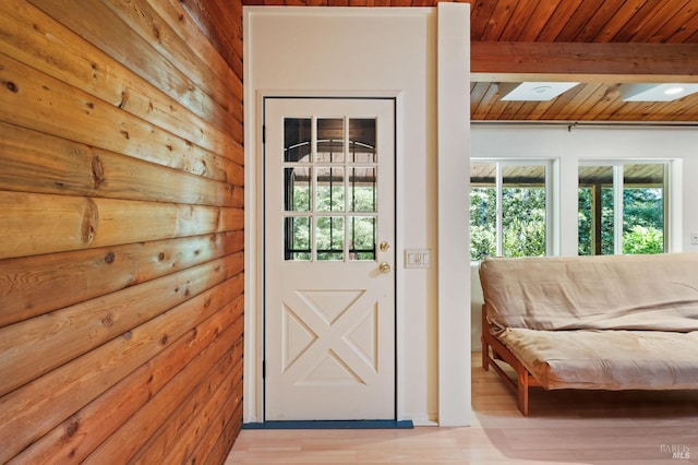 doorway to outside featuring beam ceiling, light hardwood / wood-style flooring, and wood ceiling