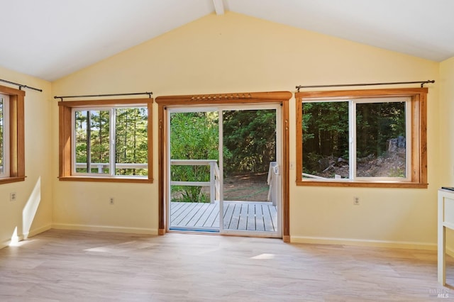 interior space with vaulted ceiling with beams and light hardwood / wood-style floors