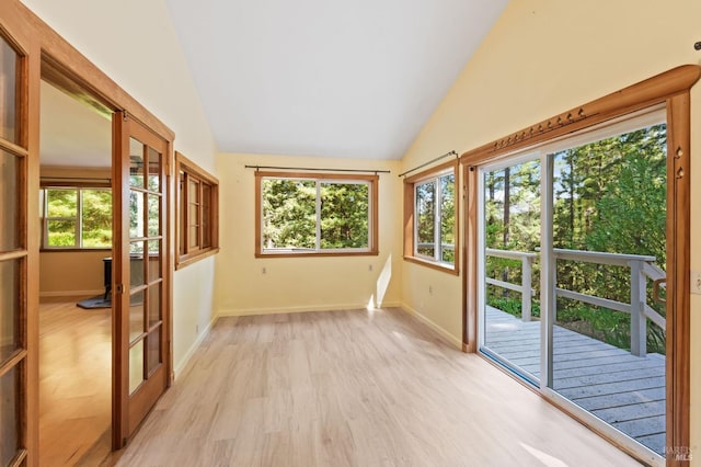 unfurnished sunroom featuring french doors, a wealth of natural light, and lofted ceiling