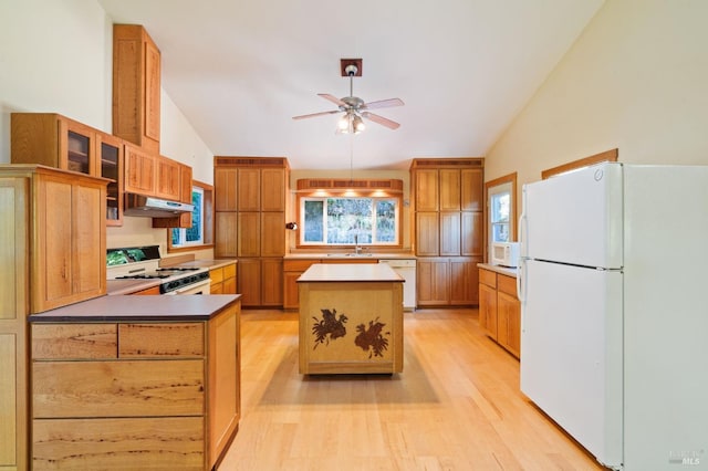 kitchen with white appliances, vaulted ceiling, ceiling fan, light wood-type flooring, and a kitchen island