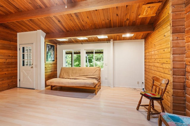 sitting room featuring lofted ceiling with beams, light wood-type flooring, and wooden ceiling