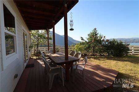 deck with outdoor dining area and a mountain view