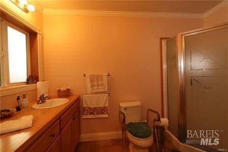 full bathroom with vanity, baseboards, a stall shower, crown molding, and toilet