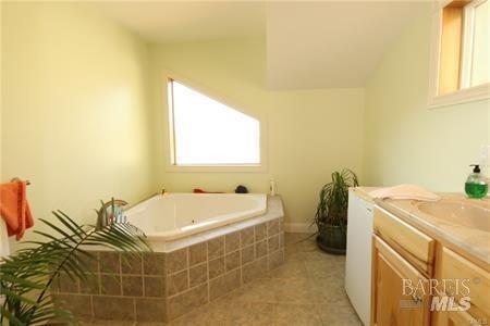 bathroom with a bath, tile patterned flooring, and vanity