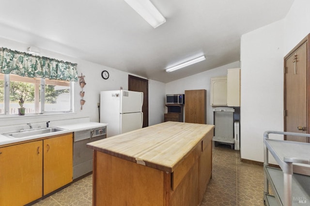 kitchen featuring dishwasher, tile flooring, white fridge, and a kitchen island