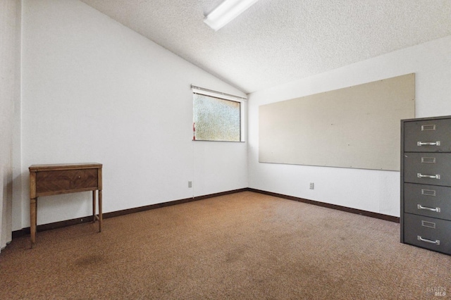 carpeted empty room featuring a textured ceiling and lofted ceiling