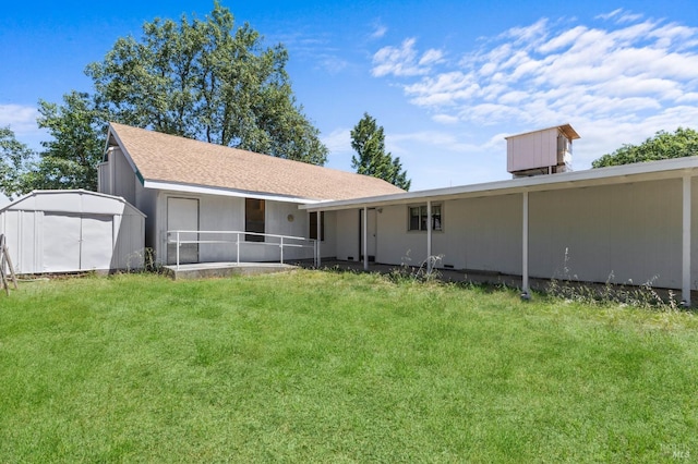 back of house with a yard and a storage unit