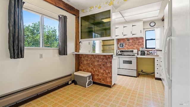 kitchen featuring a baseboard radiator, white cabinetry, light countertops, freestanding refrigerator, and gas stove