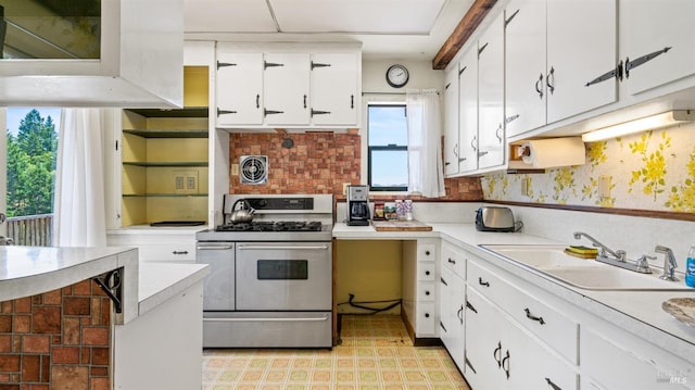 kitchen featuring range with two ovens, a sink, visible vents, white cabinetry, and light countertops