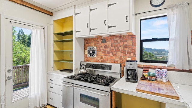 kitchen with light countertops, range with two ovens, visible vents, and white cabinets