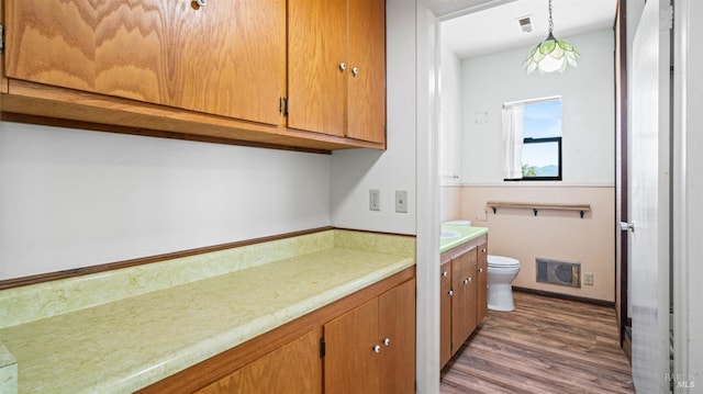 bathroom featuring visible vents, vanity, toilet, and wood finished floors