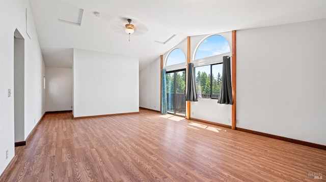 unfurnished room with lofted ceiling, wood finished floors, a ceiling fan, and baseboards