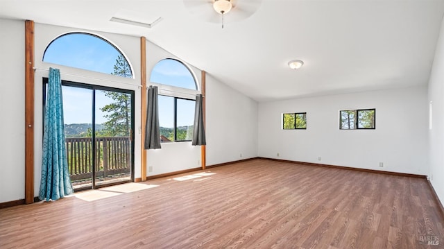 spare room with lofted ceiling, baseboards, and wood finished floors