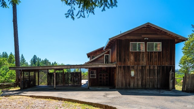 exterior space with aphalt driveway and a carport