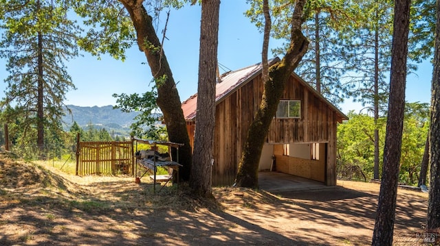 view of side of property with metal roof and a mountain view