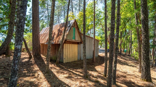 view of side of home with metal roof and an outdoor structure