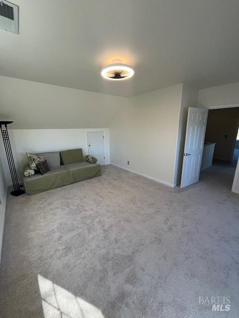 additional living space with carpet floors, baseboards, and visible vents