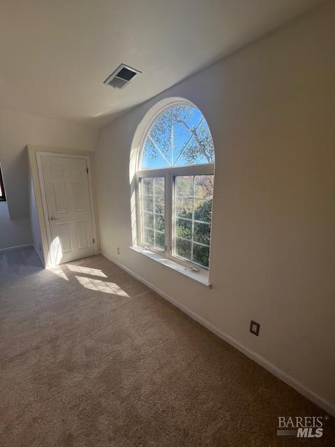 interior space featuring carpet flooring, visible vents, and baseboards