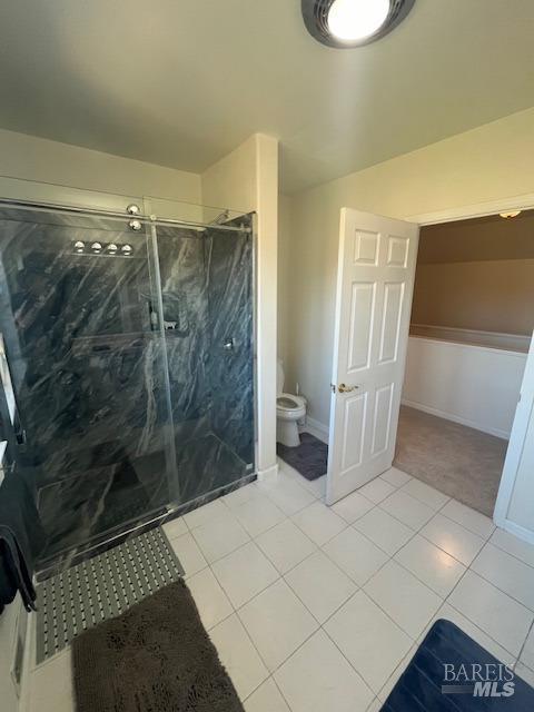 full bath with baseboards, a marble finish shower, toilet, and tile patterned floors