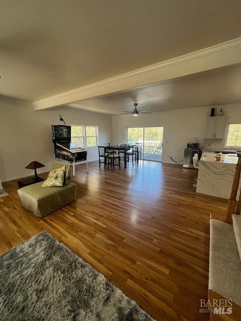 unfurnished living room featuring a wealth of natural light, a ceiling fan, and wood finished floors