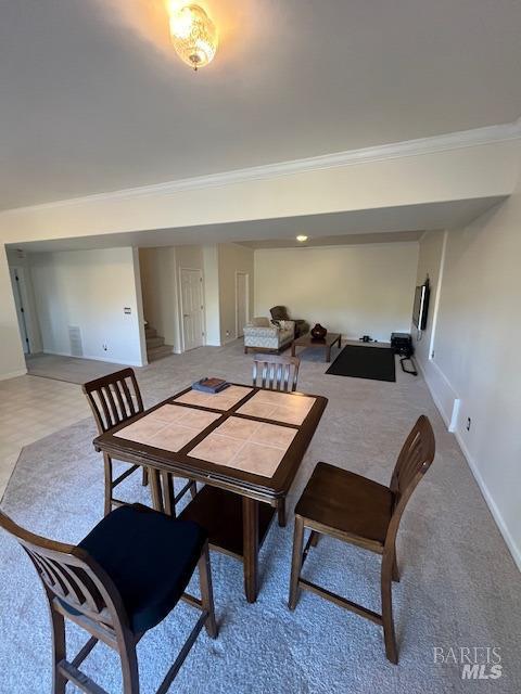 dining space with stairs, baseboards, carpet flooring, and crown molding