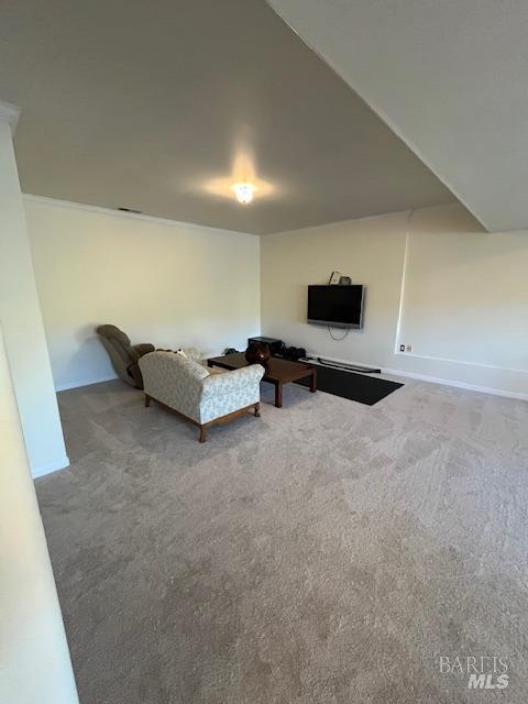 unfurnished living room featuring carpet and baseboards