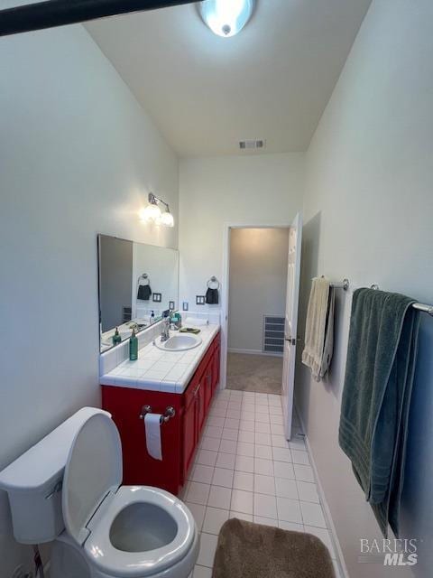 bathroom featuring tile patterned flooring, visible vents, vanity, and toilet