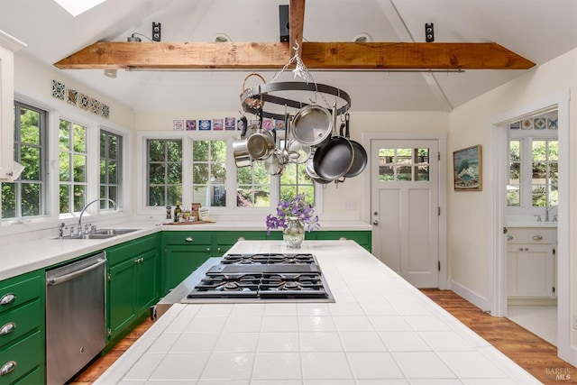 kitchen featuring tile countertops, light hardwood / wood-style flooring, stainless steel appliances, and vaulted ceiling with beams