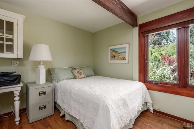 bedroom with hardwood / wood-style flooring and beamed ceiling