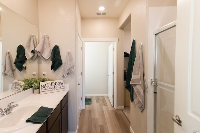 bathroom with an enclosed shower, vanity, and hardwood / wood-style flooring