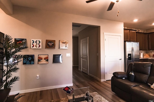 living room featuring ceiling fan and dark hardwood / wood-style flooring