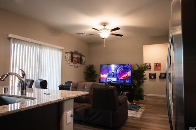 living room featuring ceiling fan, sink, and dark wood-type flooring